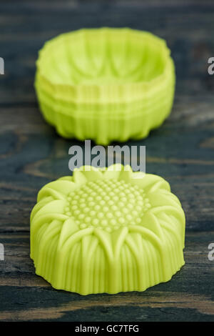 Stack of colorful silicon cake molds on blue wooden background Stock Photo