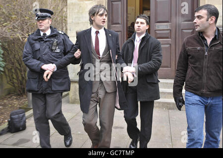 Pete Doherty is led away by police (for reasons unknown) after appearing at Gloucester Crown Court where he faced charges relating to dangerous driving and marched towards Gloucester police station on the opposite side of the road. Stock Photo