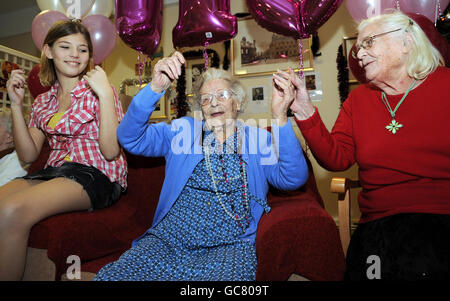 Mrs Ellen Watson, who today reached the age of 110, (centre) celebrates with family members including great great grand daughter Paige Hinde, 12, (left) and daughter Audrey Hobbs, 81, (right) at her nursing home in Staines. Stock Photo