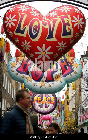 Christmas shoppers walk under inflatable Christmas decorations on Carnaby Street, in central London. Stock Photo