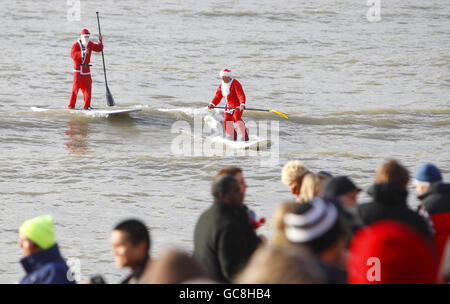 Brighton Swimming Club Christmas Day swim. Surfing Santas arrive for the annual Brighton Swimming Club Christmas Day swim in the East Sussex resort. Stock Photo