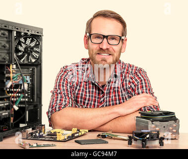 Master of computers in plaid shirt. Engineer assembling computers in the workplace. Toned image. Stock Photo
