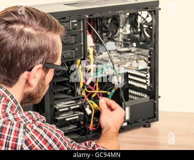 Computer engineer repairs or mount the computer. Toned image. Stock Photo