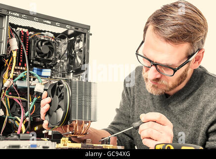 Computer technician installs cooling system of computer. Toned image. Stock Photo