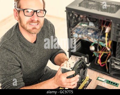 Computer technician installs cooling system of computer. Stock Photo