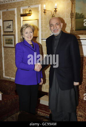 US Secretary of State Hillary Rodham Clinton, left, shakes hands with Afghan President Hamid Karzai, right, as they meet in central London. Stock Photo