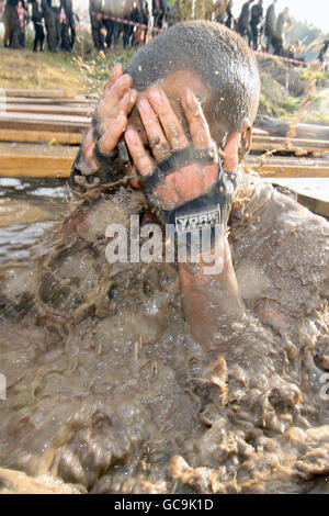 A competitor during emerges from the water tunnel during the Tough Guy challenge Stock Photo