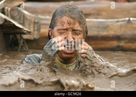 A competitor emerges from the water tunnel during tough guy Stock Photo