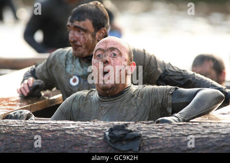 A competitor emerges from the water tunnel during tough guy Stock Photo