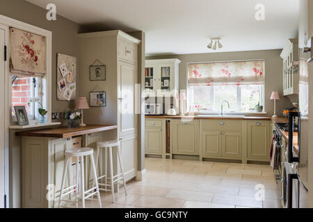 Country style kitchen with units from Neptune and tumbled limestone floor tiles. The Roman blind is made up in Kate Forma's Rose Stock Photo