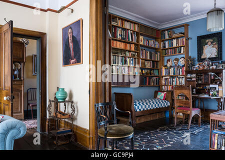 Wooden bookshelves above antique daybed in study of Nottinghill home, London, UK Stock Photo