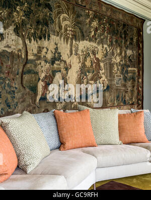 Large antique tapestry hung behind B&B Italia seating. the cushions are are by Fermoie Stock Photo