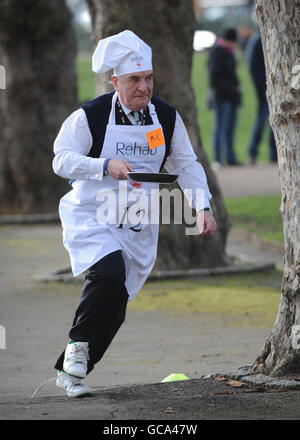Stephen Pound MP competes in the annual Parliamentary Pancake Race in Westminster, London, along with other MPs, journalists and members of the House of Lords, to raise money for the charity Rehab and to raise awareness of it's work for people with disabilities. Stock Photo