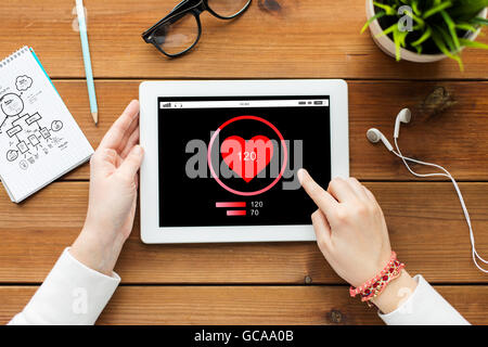 close up of woman with tablet pc on wooden table Stock Photo