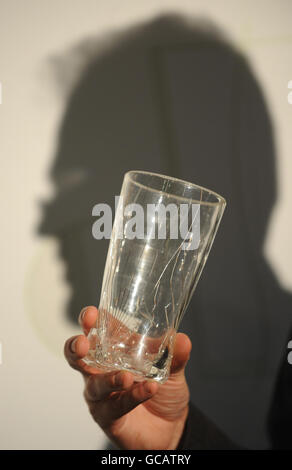 Designer David Helps looks one of the newly designed pint glasses he has developed that won't shatter on impact and are hoped to cut pub injuries when they come into use sometime next year. Stock Photo