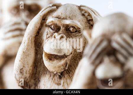 close up of hand small statues with the concept of see no evil, hear no evil and speak no evil. Stock Photo