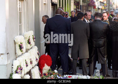 REGGIE KRAY, THE YOUNGER OF THE NOTORIOUS KRAY TWINS, ARRIVES SHELTERED BY MINDERS AT THE FUNERAL PARLOUR IN BETHNAL GREEN, LONDON, BEFORE THE FUNERAL CORTAGE, CARRYING HIS BROTHER RONNIE, LEAVES FOR ST MATTHEW'S CHURCH, BETHNAL GREEN. Stock Photo