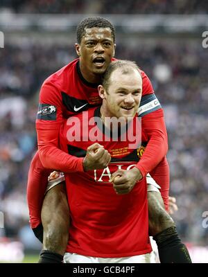 Soccer - Carling Cup - Final - Manchester United v Aston Villa - Wembley Stadium. Manchester United's Wayne Rooney (bottom) celebrates scoring his sides second goal of the game with teammate Patrice Evra (top) Stock Photo