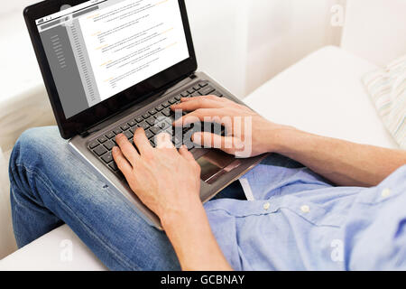 close up of man typing on laptop computer at home Stock Photo