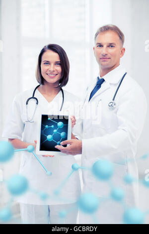 two doctors showing tablet pc with molecules Stock Photo