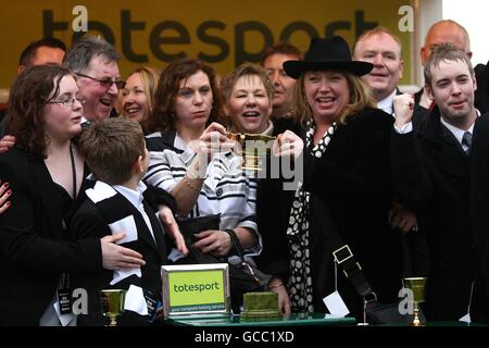 Horse Racing - 2010 Cheltenham Festival - Day Four. Members of the Our Friends in the North Raise the Gold Cup after Imperial Commander wins the Totesport Cheltenham Gold Cup Stock Photo