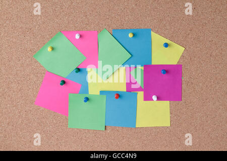 background of colored notes with colored push pins on a cork board Stock Photo
