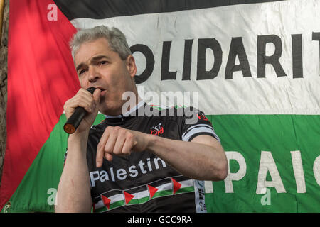 London, UK. 8th July 2016. John Hilary, Executive Director War on Want speaks at the protest at Downing St calling for an end to Israel's almost ten year siege on Gaza, and stresses the need to stop UK support for Israell and to stop selling arms to Israel and buying them from Israeli arms manufacturers who promote their weapons as having been field-tested in Gaza. There have been three major military assaults by Israel military forces on Gaza in the last 8 years, resulting in thousands of Palestinian deaths, and making the small area, home to 1.8 million people, mainly refugees and their fami Stock Photo