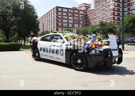 Dallas, Texas, USA. 8th July, 2016. Dallas Police officers shortly before noon on July 8th, 2016 decorate a police car outside Dallas Police headquarters with flowers donated by police and a local Sam's Club store. Credit:  Hum Images/Alamy Live News Stock Photo