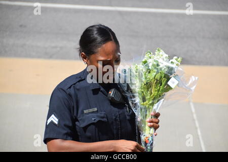 Dallas, Texas, USA. 8th July, 2016. Dallas Police officers shortly before noon on July 8th, 2016 decorate a police car outside Dallas Police headquarters with flowers donated by police and a local Sam's Club store. Credit:  Hum Images/Alamy Live News Stock Photo