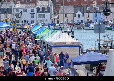 Weymouth, Dorset, UK. 9th July 2016: Crowds flock to the Dorset Seafood Festival. The award winning festival takes place in Weymouth's 17th century harbour, thought to be one of the most picturesque harbours in Europe on the 9th and 10th of July, The festival celebrates Dorset's links with its fishing communities and raises money for the Fishermen’s Mission. Credit:  Tom Corban/Alamy Live News Stock Photo