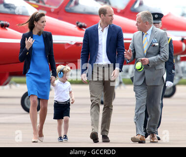 Prince George wears ear defenders as he walks with his parents the Duke and Duchess of Cambridge (left and centre) during a visit to the Royal International Air Tattoo at RAF Fairford - the world's largest military airshow. Stock Photo