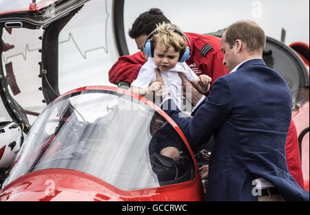 Prince George is lifted from the cockpit of a Red Arrows plane by his father the Duke of Cambridge during a visit to the Royal International Air Tattoo at RAF Fairford - the world's largest military airshow. Stock Photo