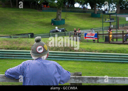 Senior spectator wearing woolly bobble hat with Cooper badge on at the VSCC event at Prescott Hill Climb,Gloucestershire, UK Stock Photo