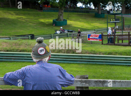 Senior spectator wearing woolly bobble hat with Cooper badge on at the VSCC event at Prescott Hill Climb,Gloucestershire, UK Stock Photo