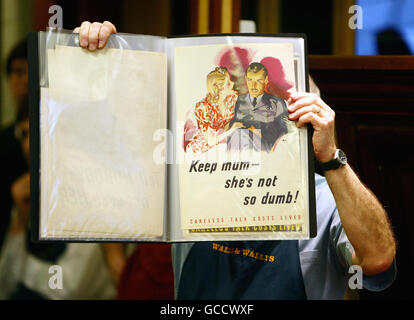 Bernard Trower, a porter at Wallis and Wallis Auctioneers, holds one of a rare collection of 150 Second World War propaganda posters which have been auctioned in the sale rooms in Lewes, East Sussex. Stock Photo