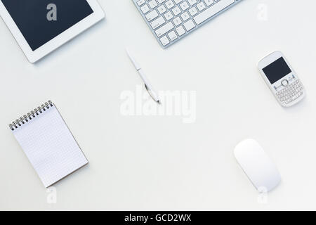 White Office Desk Table with Computer Keyboard  and Other Gadgets and Stationery Stock Photo