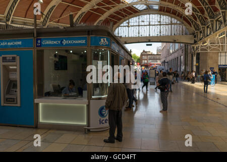 Man looking at exchange rates in the window of a Bureau De Change in a train station Stock Photo