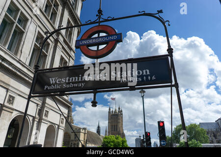 Entrance to Westminster Underground Tube Station for Commuters in London on bright sunny day with blue sky and white clouds near Houses of Parliament Stock Photo