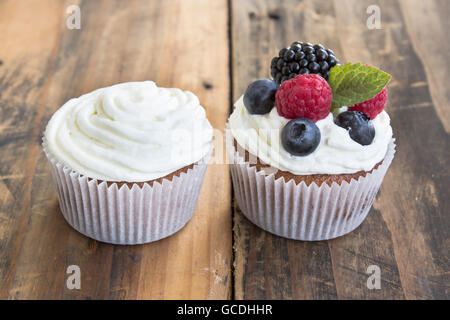 Two Different Cupcakes  on a Rustic Wooden Table. Stock Photo