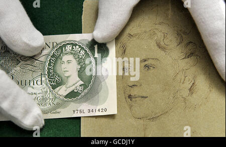 A curator displays the first 1 note in 1960 to bear Queen Elizabeth's II portrait alongside a sketch by Robert Austin which show the design at an earlier stage, at the Bank of England Museum in London - which is celebrating the 50th anniversary of the Queen's portrait on banknotes with a new exhibition. Stock Photo