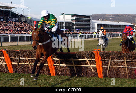 Binocular ridden by Tony McCoy (left) clears the last hurdle on his way to winning the Smurfit Kappa Champion Hurdle Challenge Trophy during day one of the 2010 Cheltenham Festival at Cheltenham Racecourse. Stock Photo