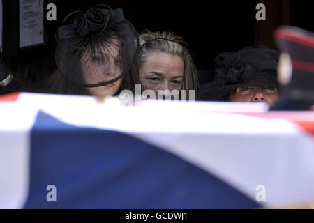 Charlotte Fox (left), widow of Sergeant Paul Fox from 28 Engineer Regiment, attached to the Brigade Reconnaissance Force, stands behind the flag draped coffin at his funeral service at St Ia's Church, St Ives, Cornwall. Stock Photo