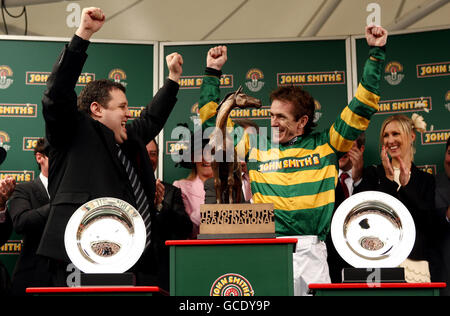 Tony McCoy (right) celebrates with Peter Kay (left) after winning the John Smith's Grand National on Don't Push It at Aintree Racecourse, Liverpool. Stock Photo