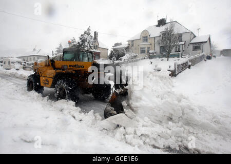 A farmer clears snow from the main street in Carronbridge, central Scotland, to allow feed lorries to access his farm after a night of heavy snow. Stock Photo