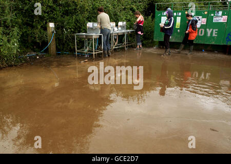 Spectators braving the rain during the Glastonbury Festival, held at Worthy Farm in Pilton, Somerset. Stock Photo