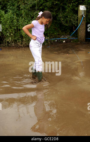 Glastonbury 2004. Spectators braving the rain during the Glastonbury Festival, held at Worthy Farm in Pilton, Somerset. Stock Photo