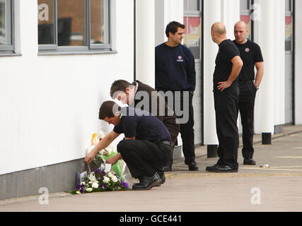 A fire officer lays flowers outside the fire station in St Marys in Southampton after fire fighters Alan Bannon and James Shears based at the station were killed during a fire at Shirley Towers in the Shirley area of the city overnight. Stock Photo