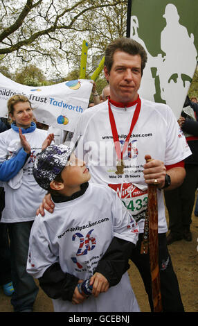 Major Phil Packer (right), who suffered a spinal cord injury serving in Basra, Iraq, after completing the 2010 Virgin London marathon, with a supporter, at The Mall, London. Stock Photo