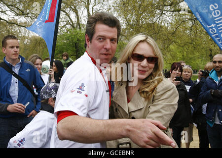 Major Phil Packer (left), who suffered a spinal cord injury serving in Basra, Iraq, after completing the 2010 Virgin London marathon, with a supporter, at The Mall, London. Stock Photo