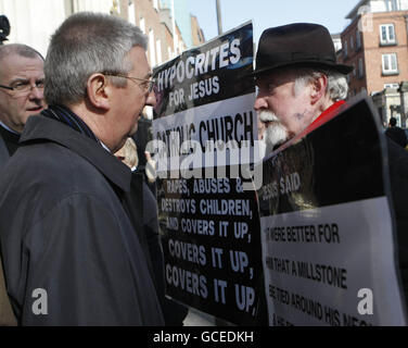 Eamon Reid (right), a survivor of clerical abuse confronts Archbishop Diarmuid Martin (right) on his way into Easter Sunday Mass at St Mary's Pro-Cathedral, Dublin. Pressure has been mounting on the Catholic Church since a bombshell report in November that detailed decades of child abuse in Ireland and found paedophile priests were shielded by peers and officials. Stock Photo